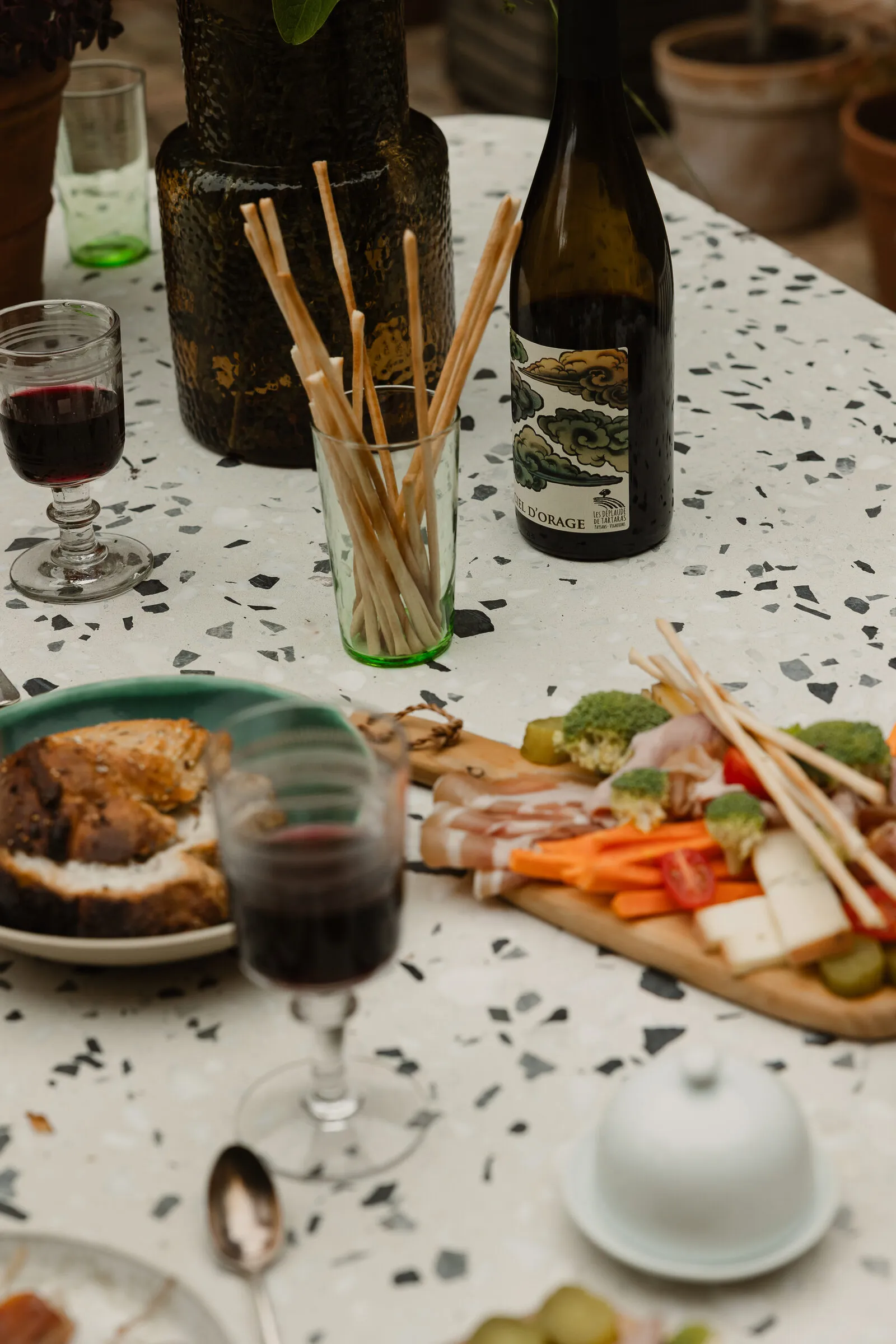 Planche apéro généreuse — charcuterie et fromages sur une table en terrazzo