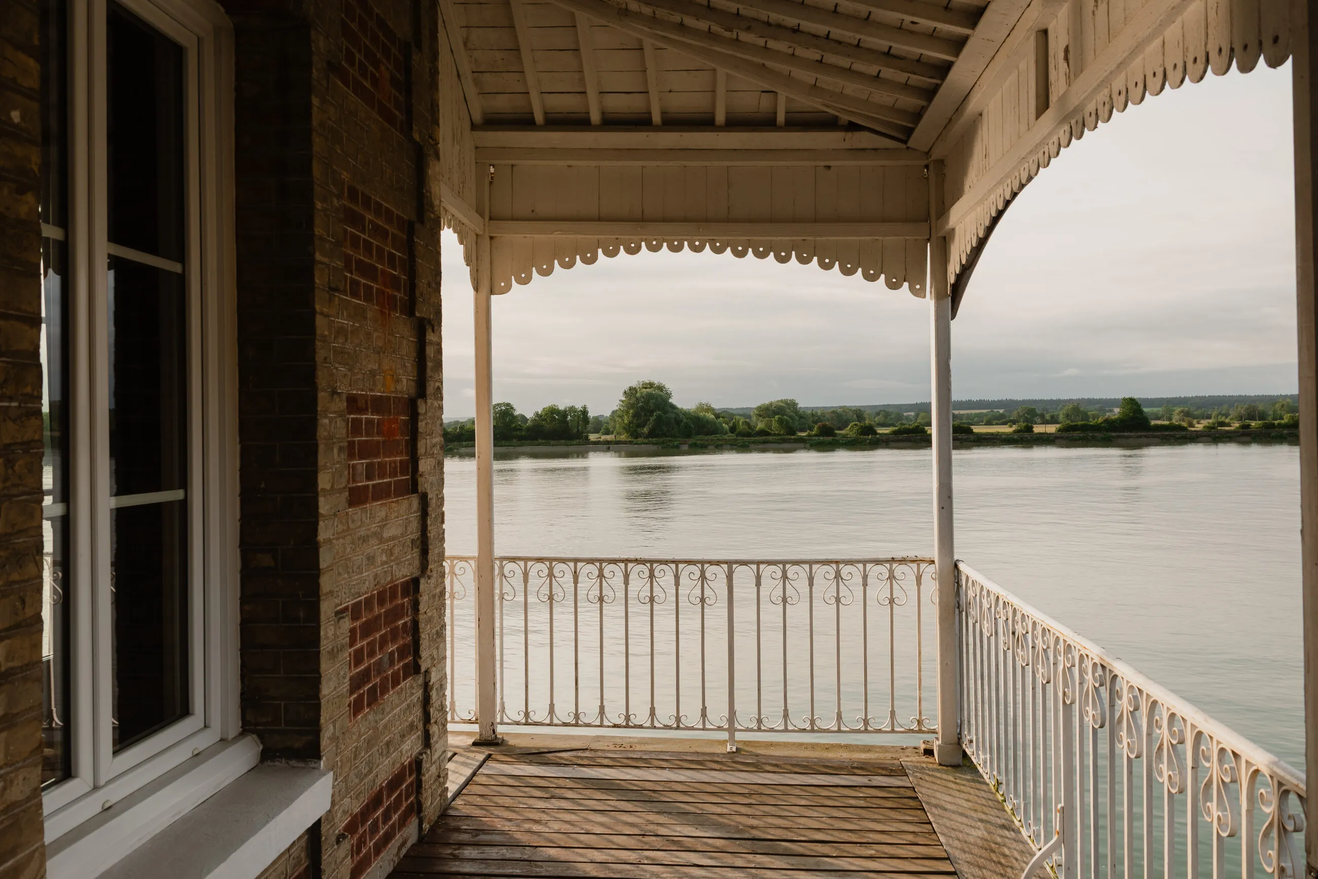 La terrasse couverte de la maison ouvre sur la Seine, sous une arche de brique